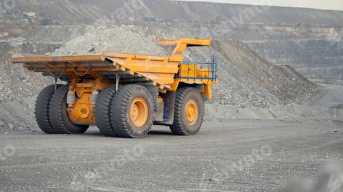 Preview: Close-up of dump truck moving on a quarry road loaded with ore. Back view.