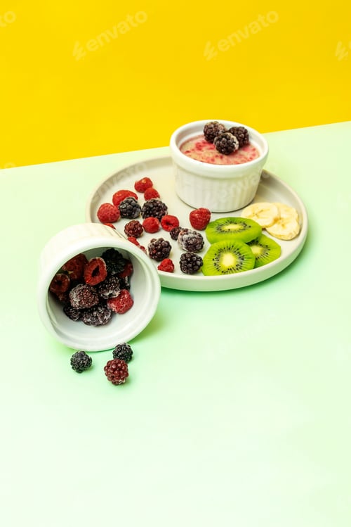 Preview: ice cream with frozen banana kiwi fruits,berries. Cold summer homemade dessert food on gray plate