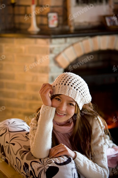 Preview: Young woman smiling in front of a fireplace