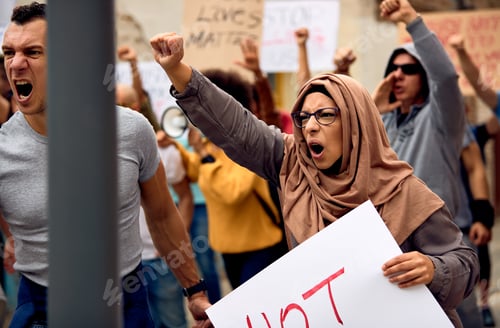 Preview: Muslim woman with raised fist supporting anti-racism movement.