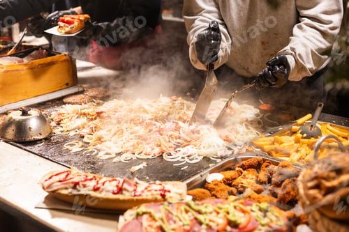 Preview: vendor fries meat on the grill in the city center at the Christmas market