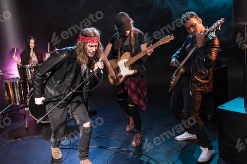 Preview: Handsome singer with rock and roll band performing music on stage