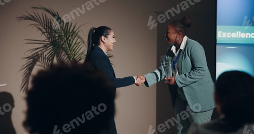 Preview: Business women, handshake and smile for prize, congratulations or meeting on event stage. Celebrati