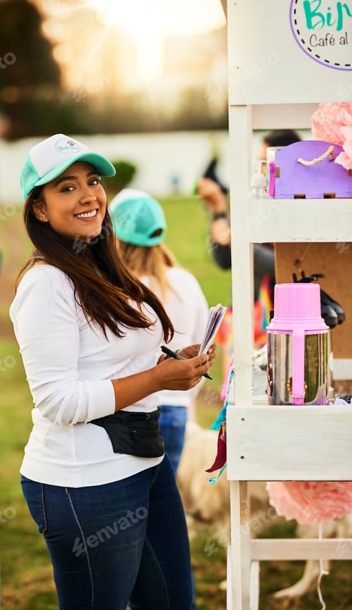 Preview: Shot of a cheerful young woman standing next to her baked goods stall while looking at the camera
