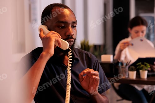 Preview: Project manager discussing startup strategy plan on landline phone