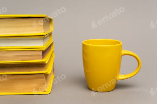 Preview: stack of yellow notebooks near mug on grey
