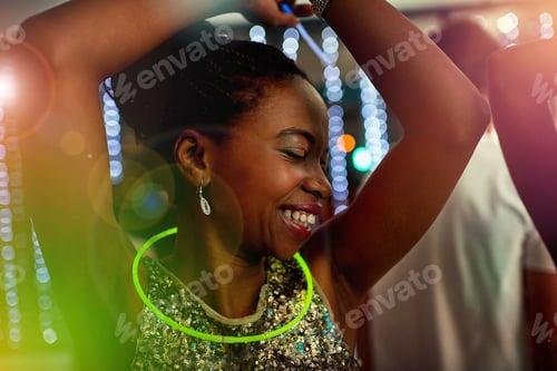 Preview: Put your hands in the air. Shot of a beautiful young woman dancing in a nightclub.