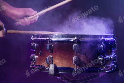 Preview: The drummer plays the drums. Beautiful blue and red background, with rays of light.