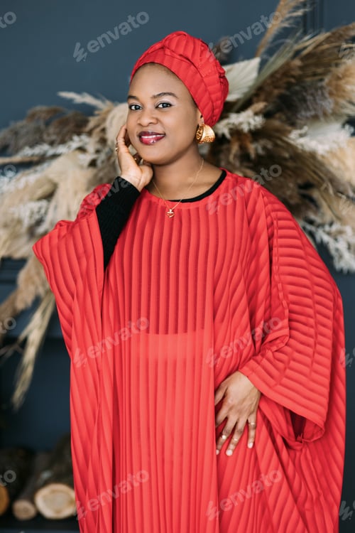 Preview: Portrait of stunning pretty African woman with in red dress and traditional shawl on her head