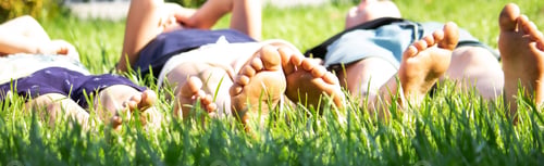 Preview: Children's legs on green grass. Selective focus.