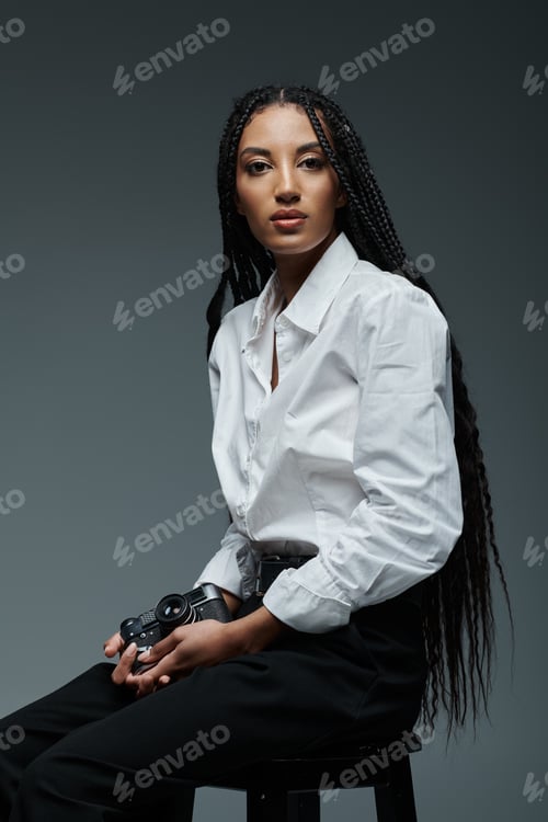 Preview: Stylish woman in white shirt holds camera