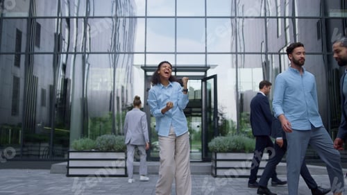 Preview: Excited business woman celebrating promotion in contemporary glass office facade