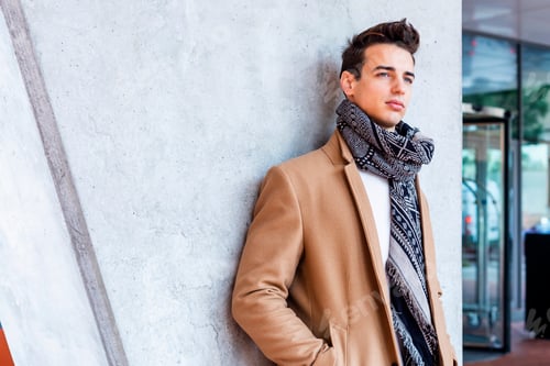 Preview: Stylish young man in coat and scarf outdoors