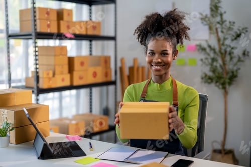 Preview: A woman is smiling and holding a cardboard box