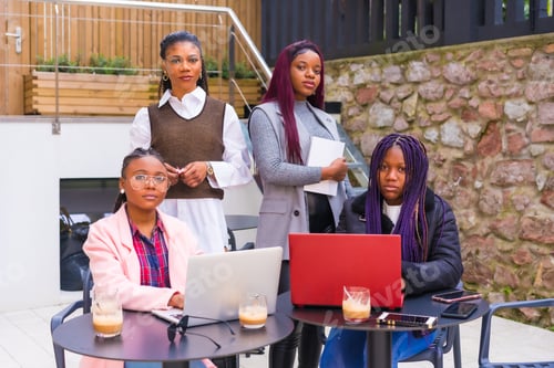 Preview: Young and alternative businesswomen of black ethnicity. In a teamwork meeting, in a cafeteria