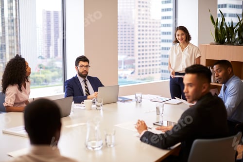 Preview: Businesswoman Standing Giving Presentation To Colleagues In Modern Open Plan Office