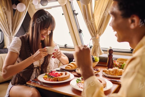 Preview: Smiling Couple Enjoying Breakfast Inside RV