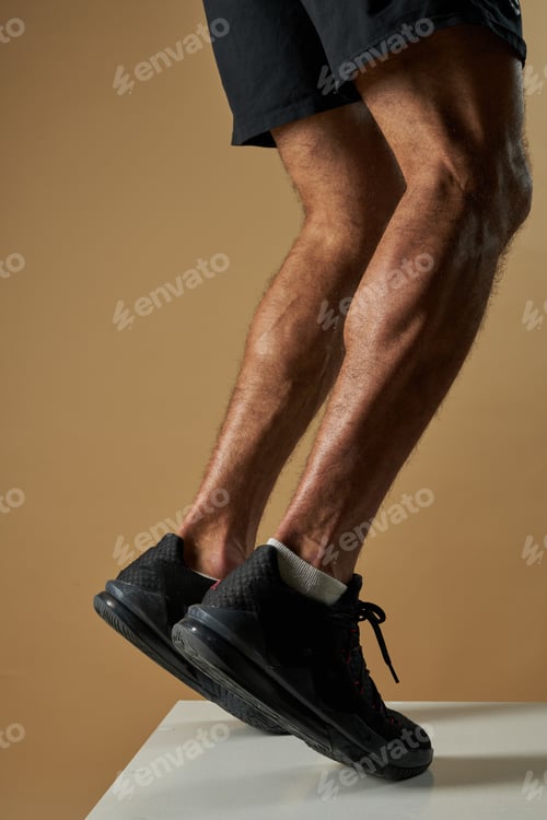 Preview: Strong muscular male legs in black sneakers