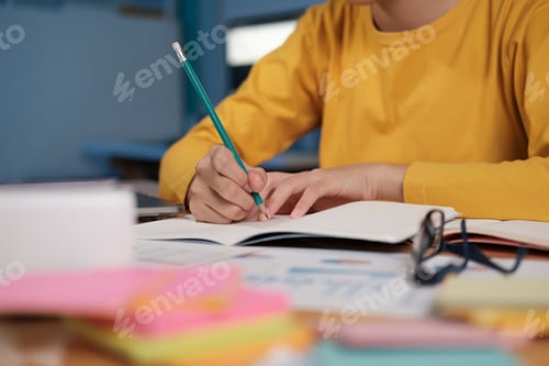 Preview: Close up hands with pen writing on notebook.