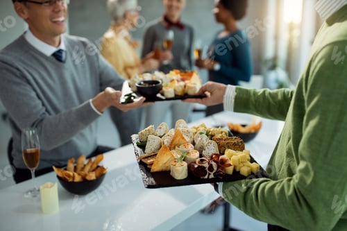 Preview: Close-up of business colleagues serving food during office party.