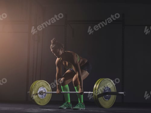 Preview: Young woman lifting barbell
