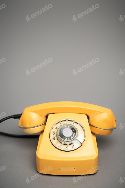 Preview: yellow and retro telephone on grey background