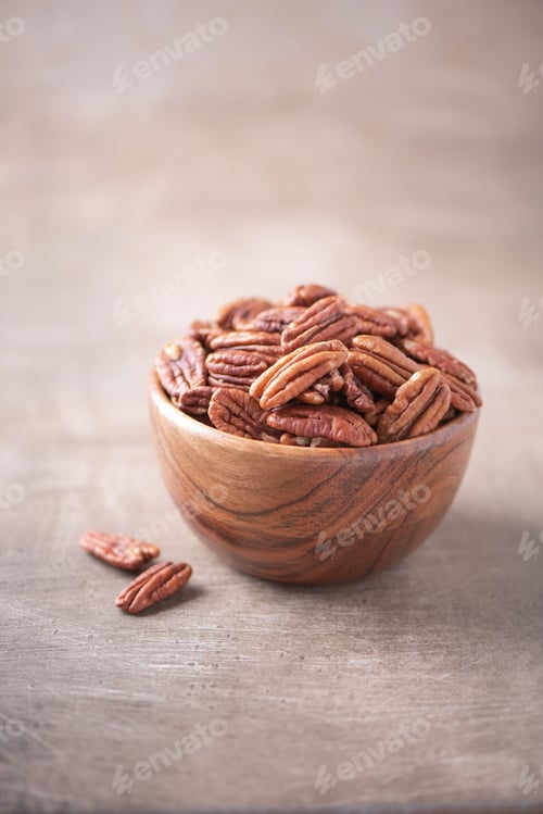 Preview: Pecan nuts in wooden bowl on wood textured background. Copy space. Superfood, vegan, vegetarian food