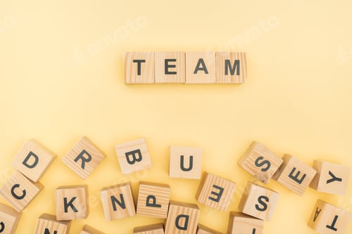 Preview: top view of team lettering with wooden cubes on yellow background