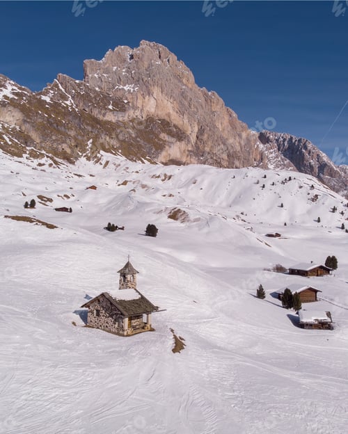 Preview: Vertical shot of houses on a steep mountain covered with white snow during winter