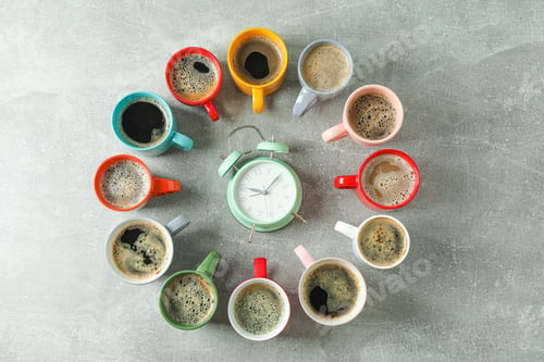 Preview: Multicolored cups of coffee circle and alarm clock on grey background, top view and space for text