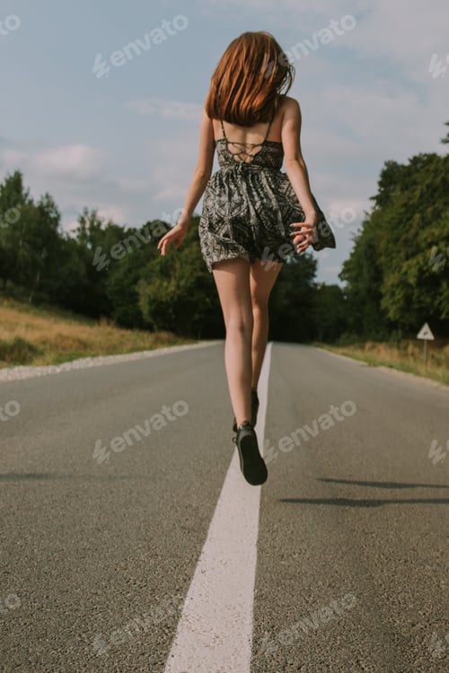 Preview: Happy girl in a dress travelling on the road