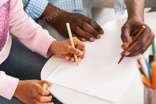 Preview: Closeup of African American child with grandfather drawing with markers on blank sheet of paper