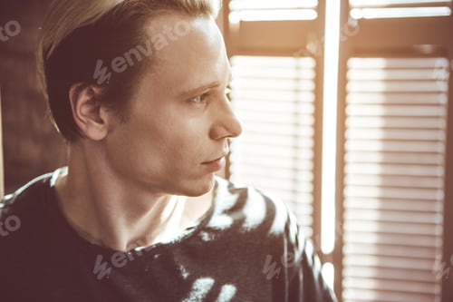 Preview: Confidence. Close Up Toned Portrait Of Attractive Guy With Dyed Hair Standing Near Jalousie And
