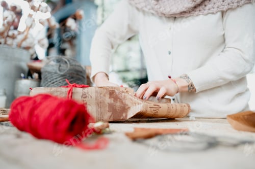 Preview: Wrapped up in holiday spirits, hands busy at work with wrapping paper and festive decorations.