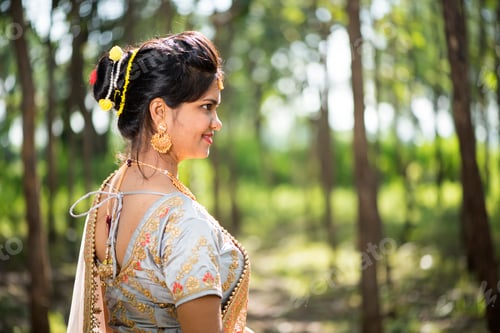 Preview: Beautiful Indian bride in traditional wedding dress at outdoor.