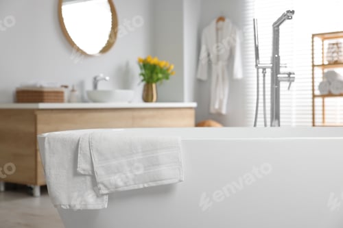 Preview: Fresh white towels on tub in bathroom. Space for text