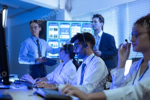 Preview: Customer support team working in a high-tech call center office at night