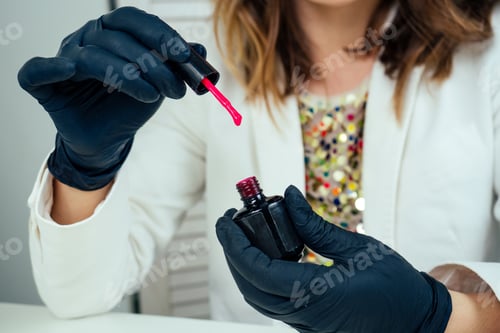 Preview: close-up hands of manicurist professional (master of manicure) woman in a white jacket