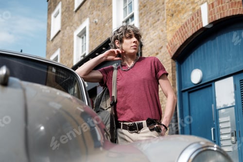 Preview: Portrait of androgynous female leaning on antique car.