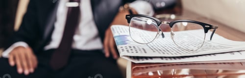 Preview: panoramic shot of glasses and newspaper on table in private plane