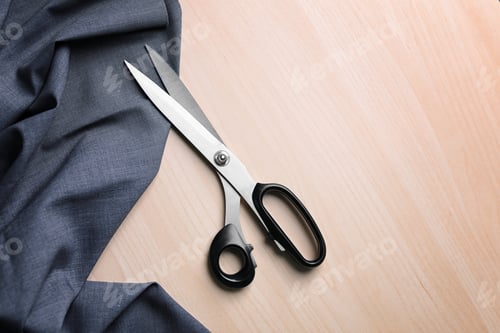 Preview: Scissors and fabric for tailoring on light wooden background