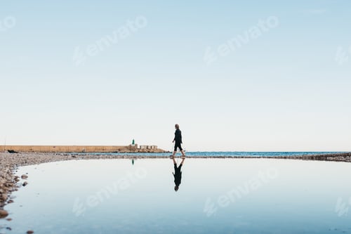 Preview: Unrecognizable woman walking near water
