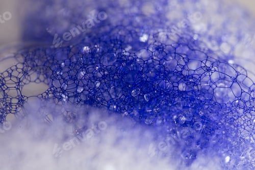 Preview: Closeup of blue translucent soap bubbles floating on the water surface, perfect for backgrounds