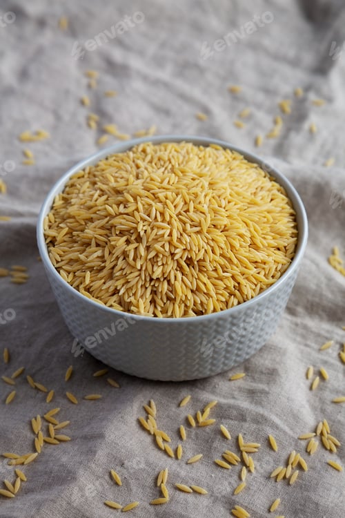 Preview: Raw Organic Risoni Pasta in a Bowl, side view.