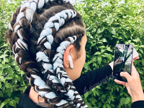 Preview: A girl with blue braids using white Bluetooth wireless headphones. || Outdoors || Natural light