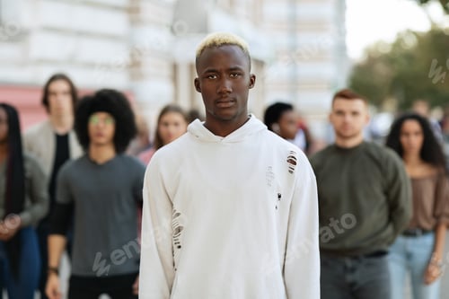 Preview: Serious african american man standing over multiracial group