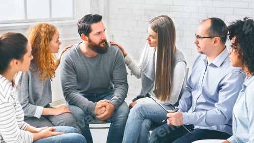 Preview: Therapy Group Members Comforting Upset Man On Community Meeting In Rehab