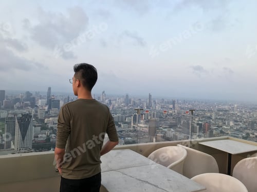 Preview: Young man looking over city of Bangkok