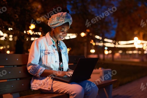Preview: Woman working on laptop in the park