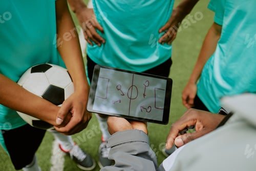 Preview: Group of Teen Boys Discussing Soccer Tactics Using Digital Tablet Outdoors